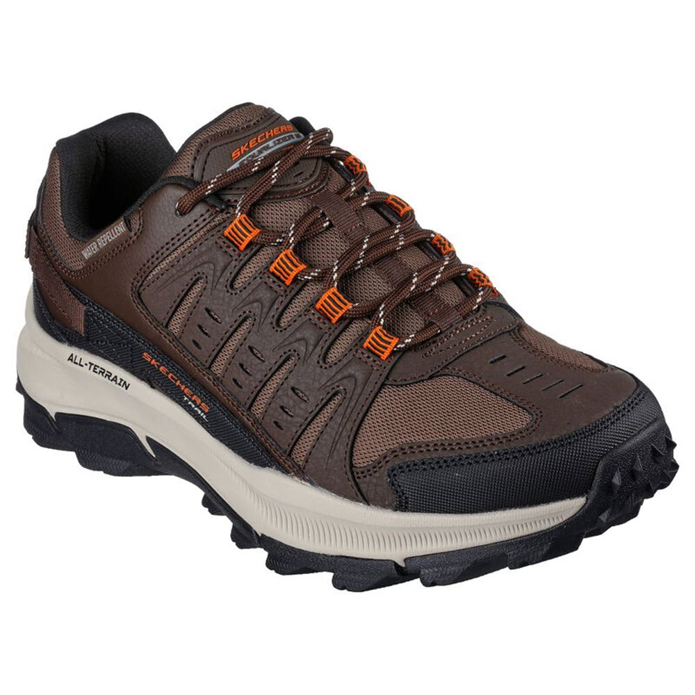 Skechers brown and gray trail running shoe with orange laces and a rugged, water-repellent sole, isolated on a white background.