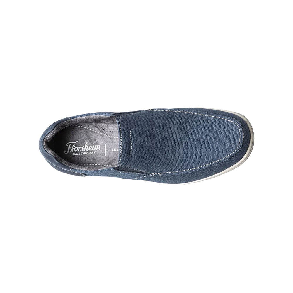 Top view of a single navy blue Florsheim Lakeside slip-on shoe with white stitching on a white background.