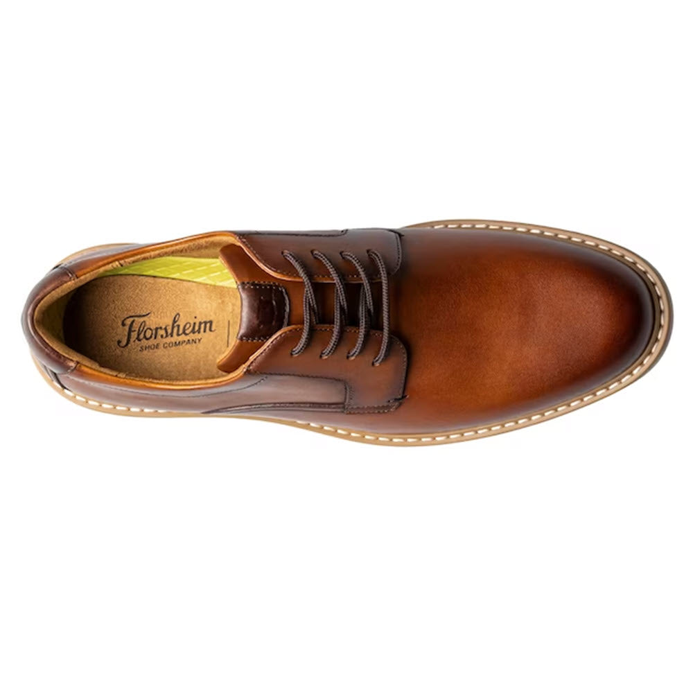 Top view of a single brown leather Florsheim Norwalk Plain Toe Oxford Cognac Smooth dress shoe with laces and a visible brand name inside.