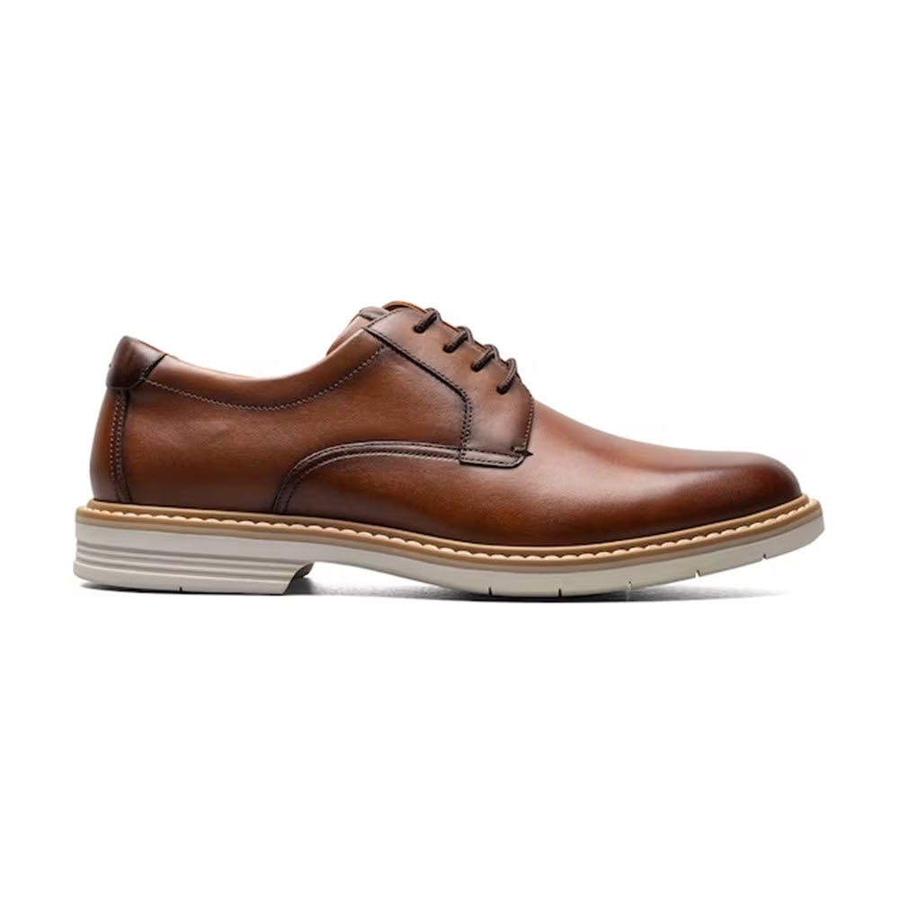 A brown leather Florsheim Norwalk Plain Toe Oxford with laces, featuring a low heel and a contrasting white sole, isolated on a white background.