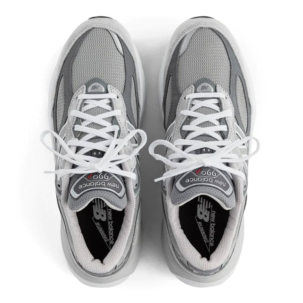 A pair of New Balance 990 V6 running shoes in gray, viewed from above, with white laces neatly tied.