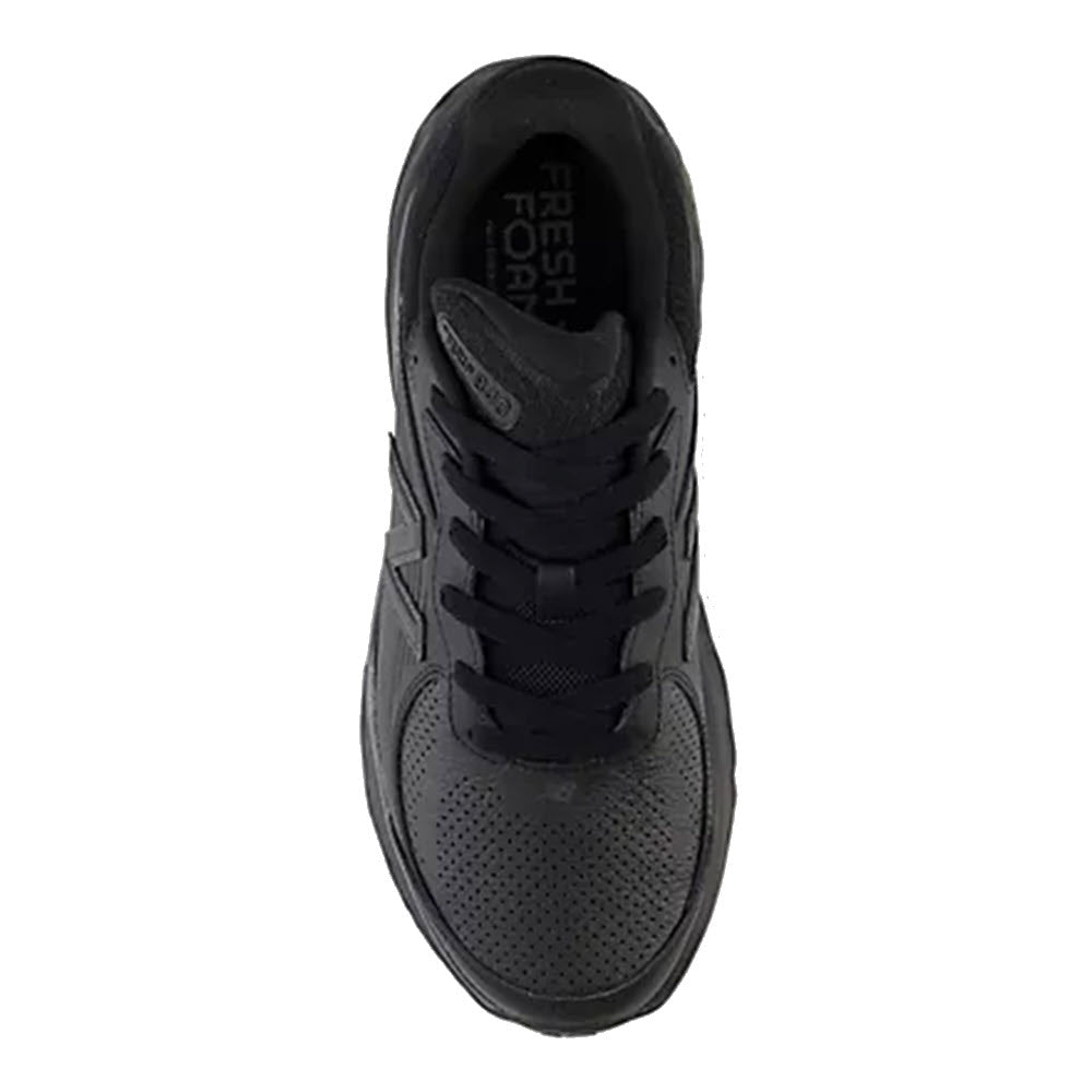 Top view of a New Balance Slip Resistant Fresh Foam X 840V1 black athletic walking shoe with textured design and visible brand label on the tongue.