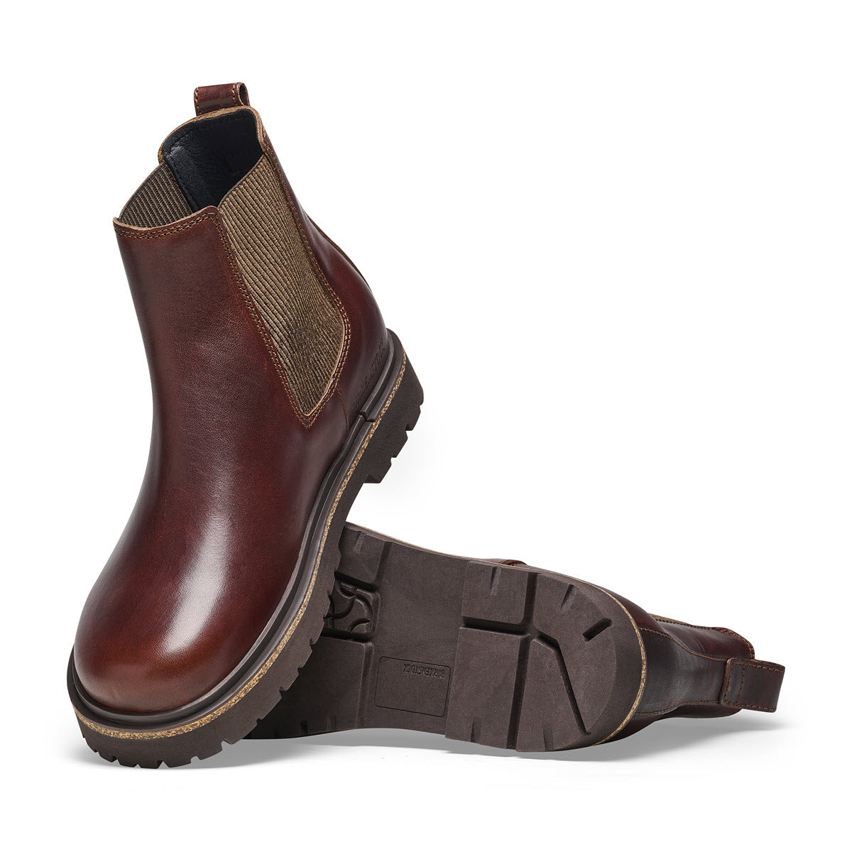 A single brown natural leather Birkenstock Chelsea boot with elastic side panels and a sturdy cork sole, shown from a side angle on a white background.