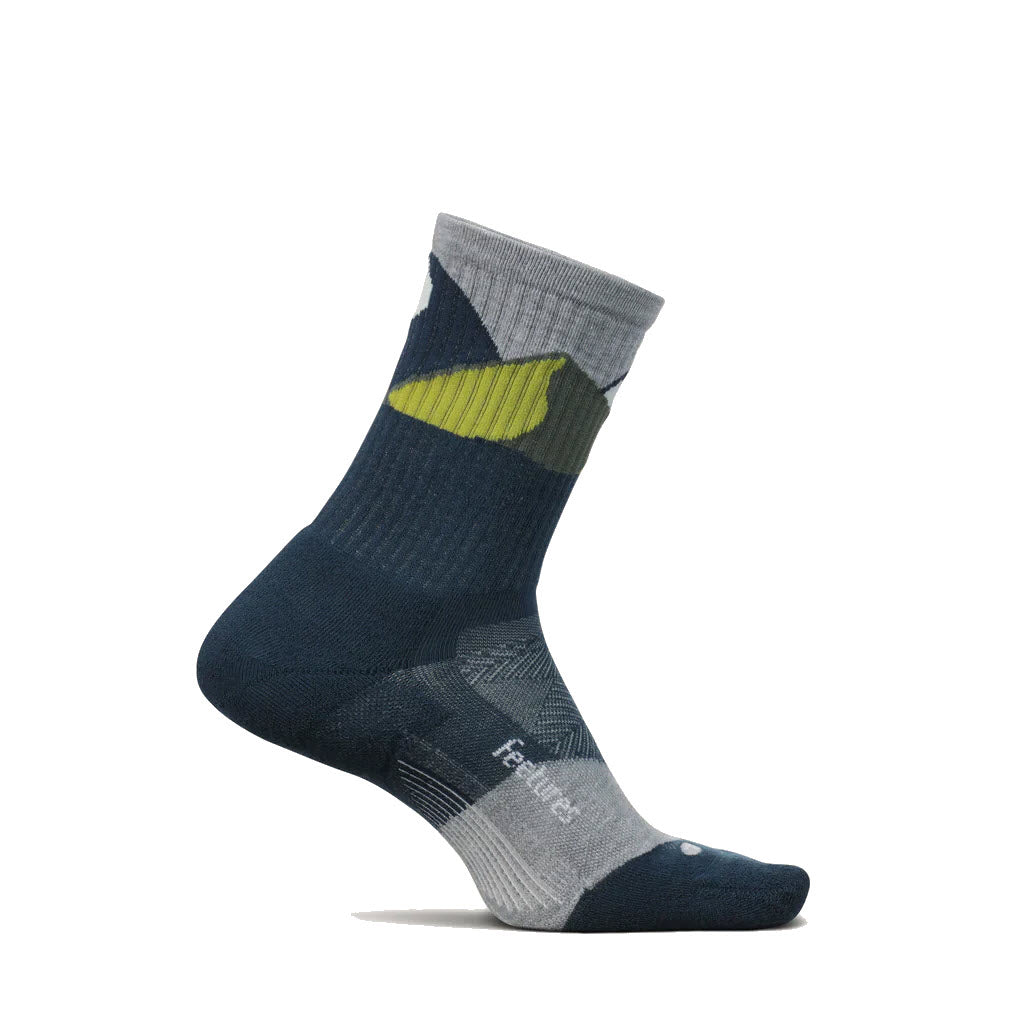 A single Feetures sock featuring a tri-tone design with navy blue at the top, gray in the middle, and a green stripe with targeted compression, displayed against a white background.