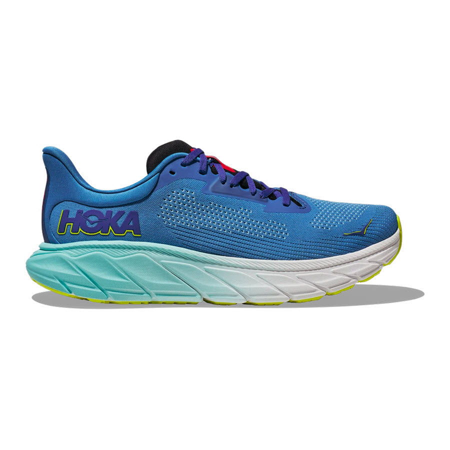 Blue HOKA Arahi 7 running shoe with a prominent logo, yellow accents, and a chunky, sculpted sole featuring J-Frame technology.