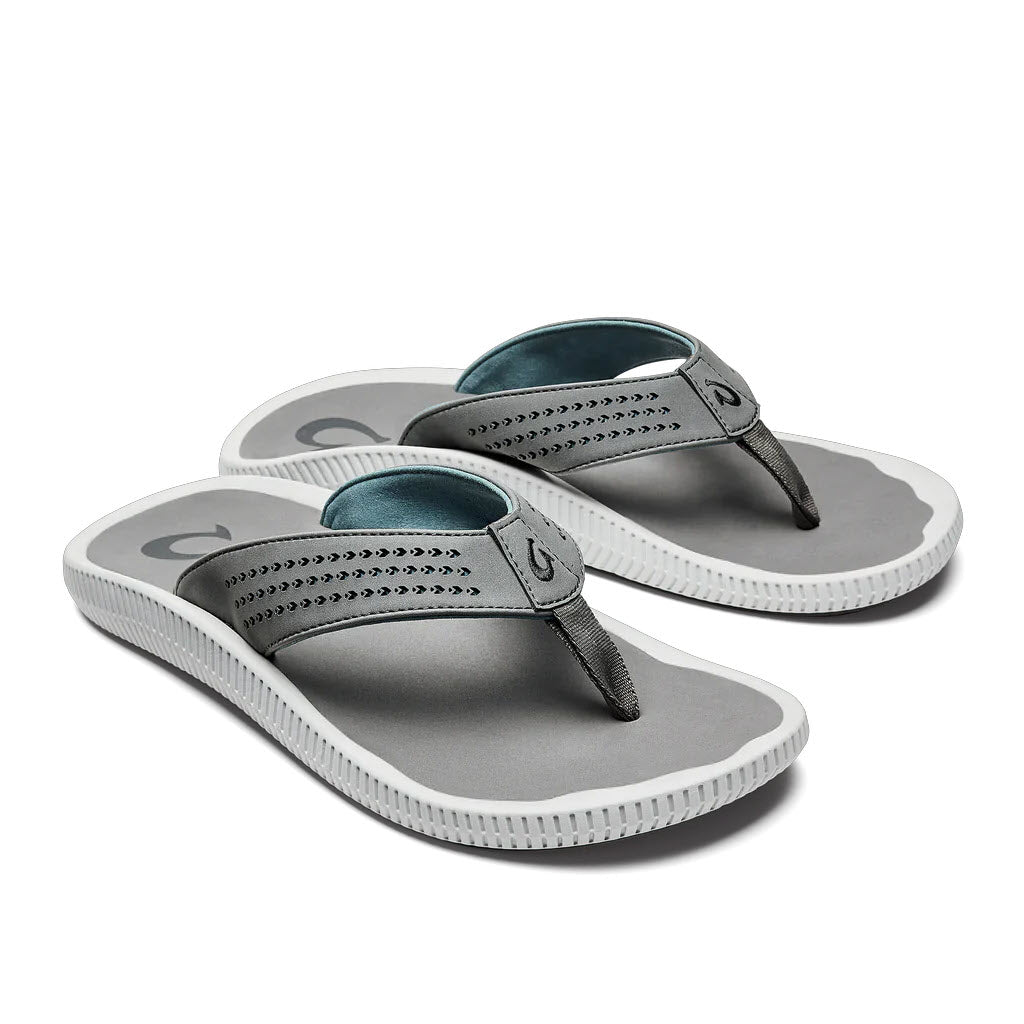 A pair of gray Olukai Ulule water-friendly flip-flops with teal straps on a white background.