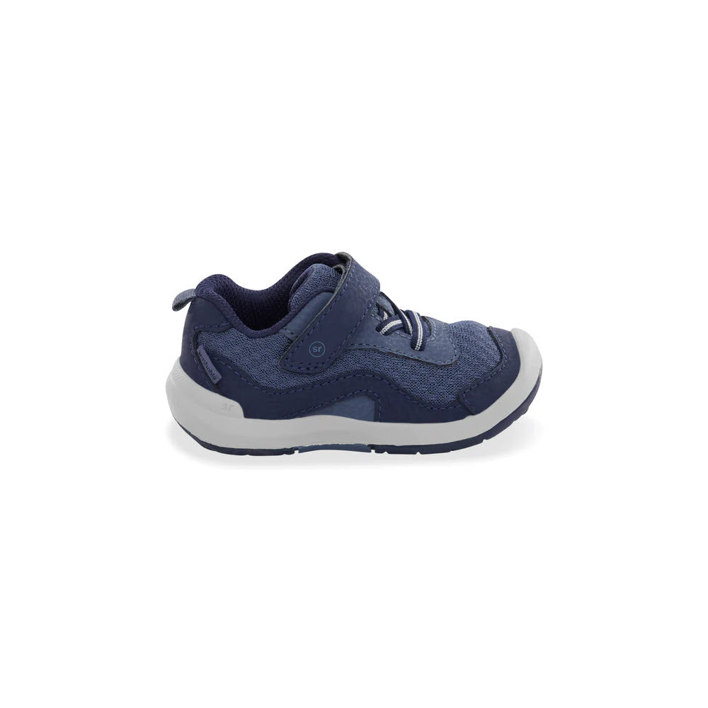 A single navy blue Stride Rite SRT Winslow 2.0 Sneaker with white soles and a Velcro strap, isolated on a white background.