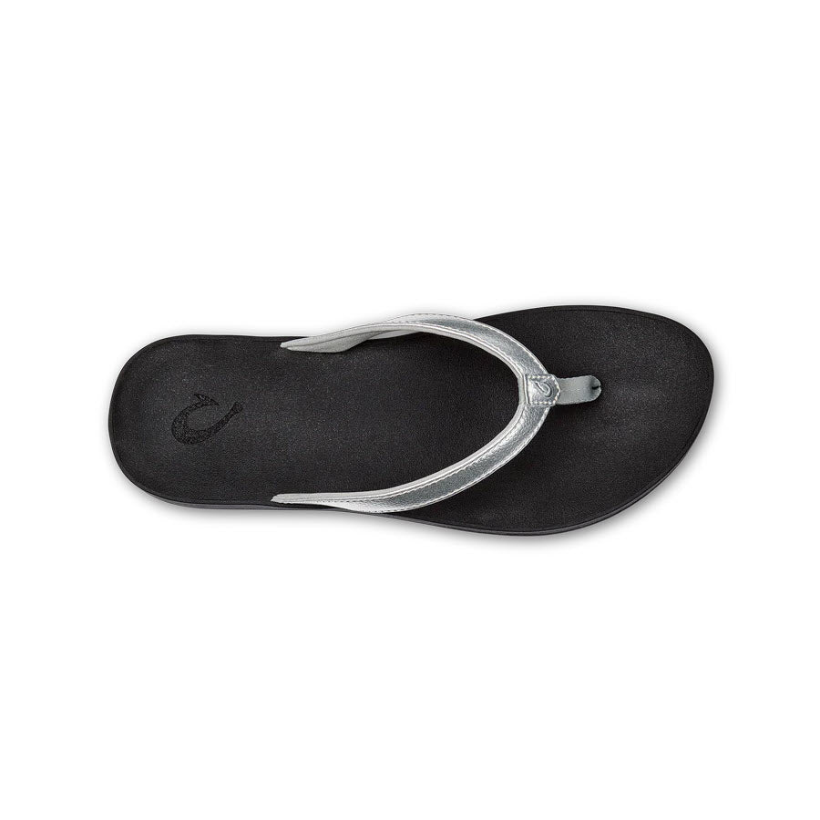 Single Olukai Puawe Silver flip-flop with a silver strap, an everyday sandal isolated on a white background.
