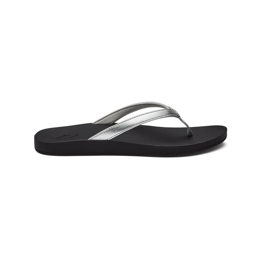 A pair of black Olukai Puawe Silver sandals with silver straps isolated on a white background.
