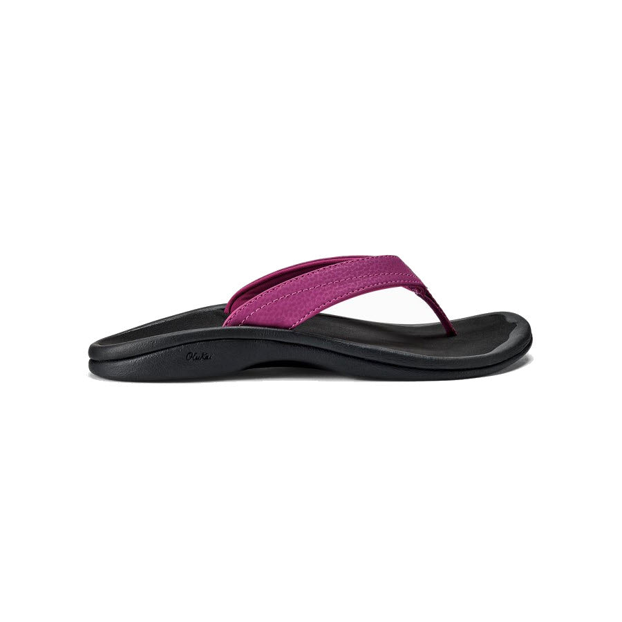 A single black Olukai beach sandal with a bright pink strap, set against a white background.
