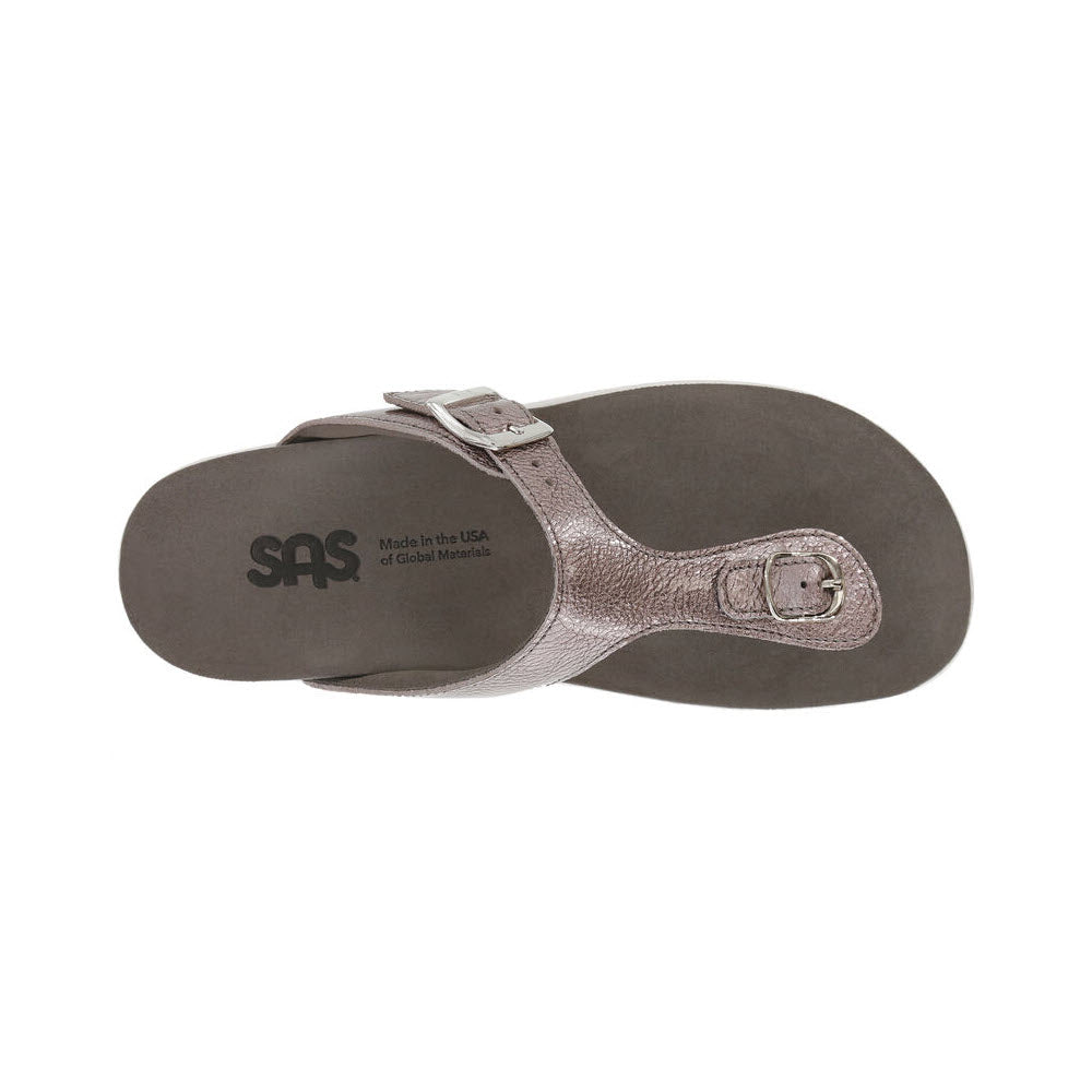 Top view of a single silver SAS Sanibel Wisteria women&#39;s sandal with an adjustable strap, highlighting its suede footbed and label stating &quot;made in the USA of global materials.