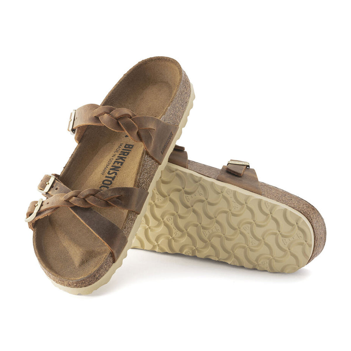 A pair of Birkenstock Franca Braid Cognac leather sandals with buckles, displayed against a white background, showing both the top and the treaded sole.