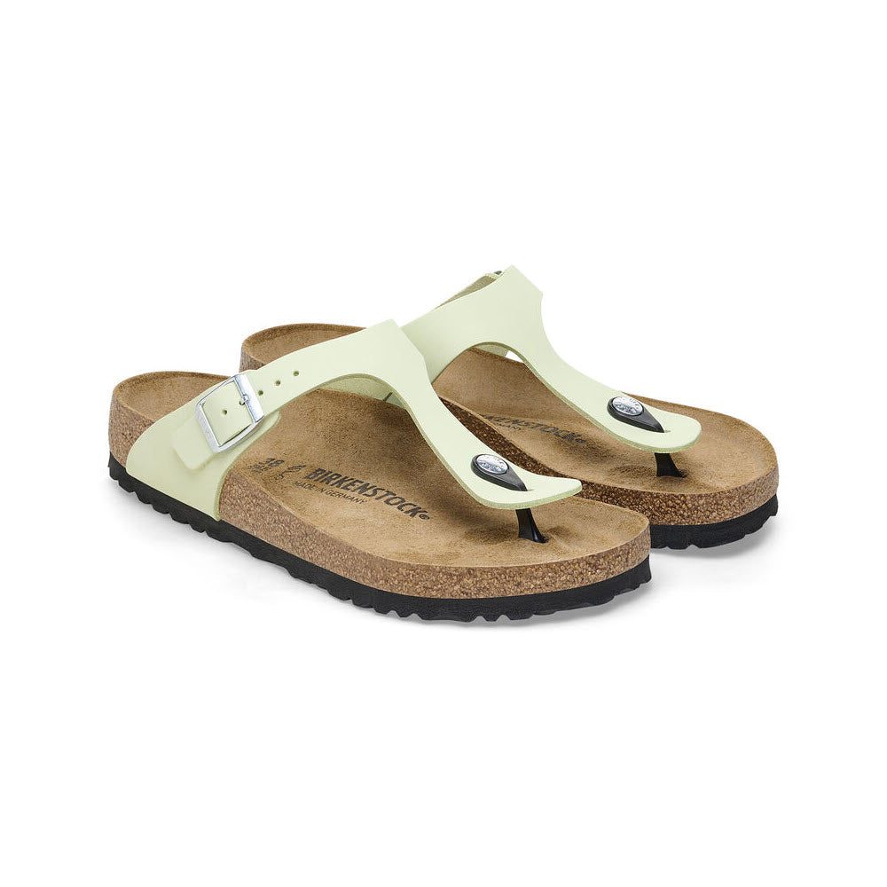 A pair of light green Birkenstock Gizeh Faded Lime sandals with nubuck leather uppers and adjustable straps on a white background.