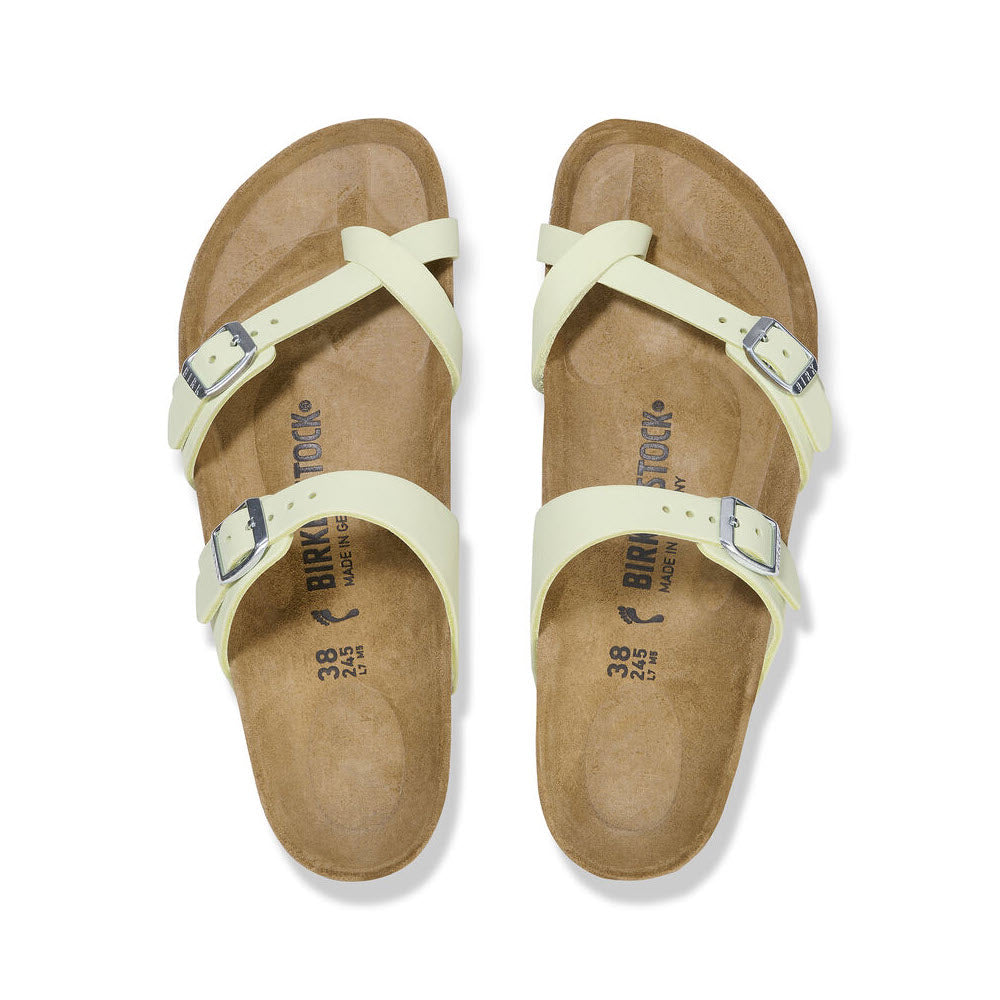 A pair of light yellow Birkenstock Mayari Faded Lime sandals with adjustable straps, displayed on a white background, viewed from above.