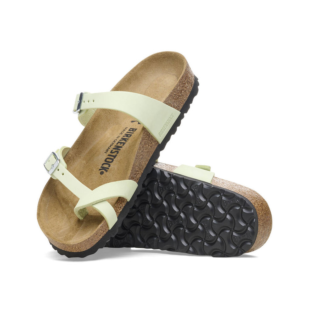 A pair of light green Birkenstock Mayari Faded Lime sandals with cork-latex footbeds and black soles, positioned against a white background.