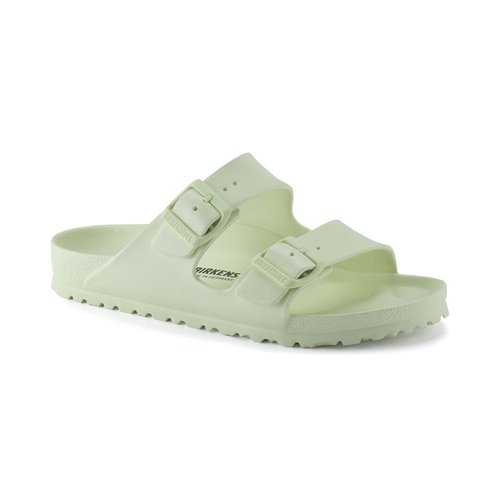 A pair of light green Birkenstock Arizona EVA Faded Lime sandals with two adjustable straps, displayed against a white background.