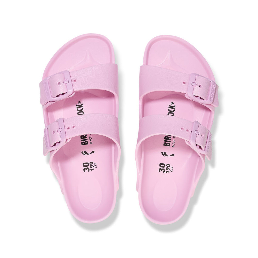 A pair of pink Birkenstock kids sandals with adjustable straps, viewed from above on a white background.