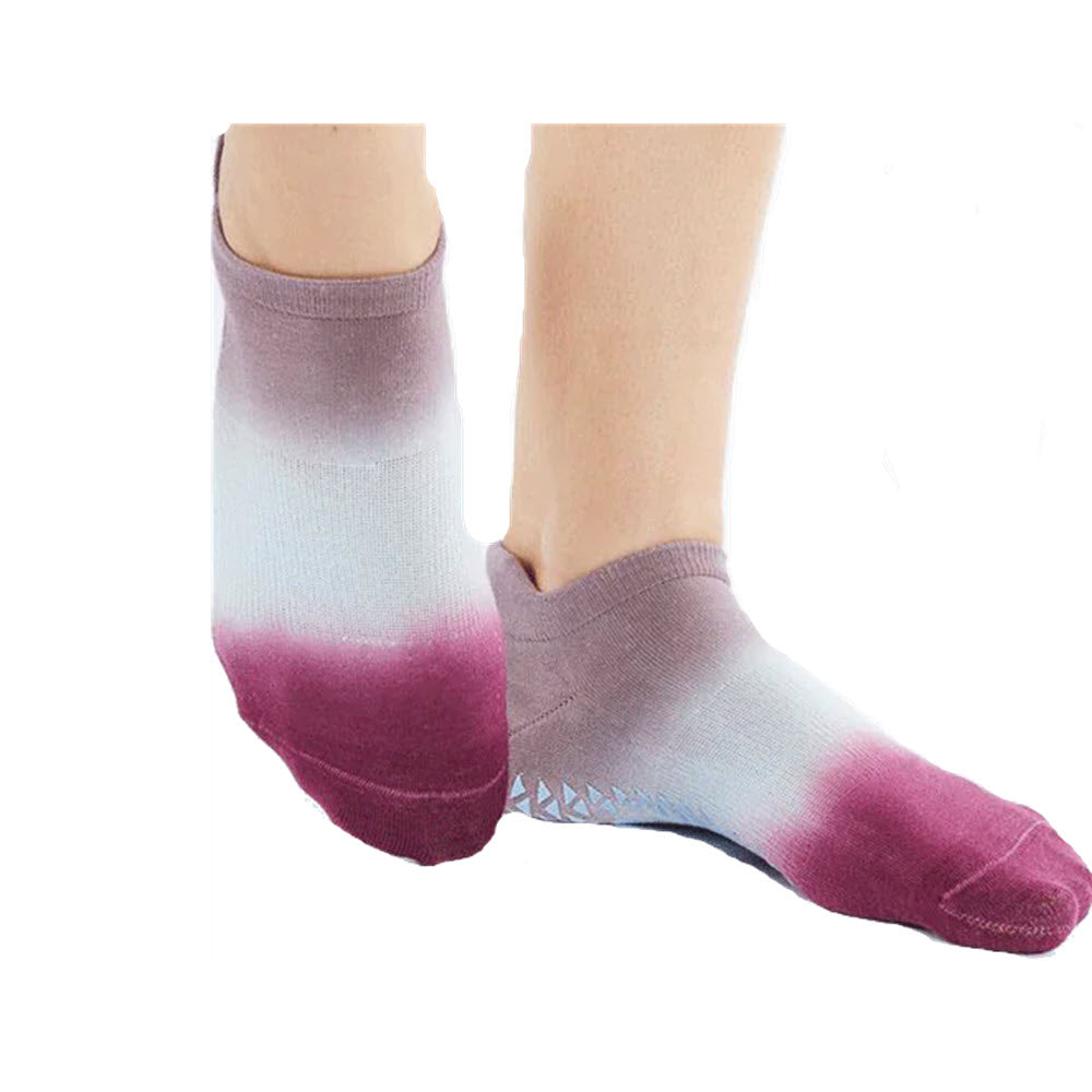 A pair of POINTESTUDIO Wyatt Low Grip Socks in Berry, transitioning from white to purple, shown on a person's feet against a white background.