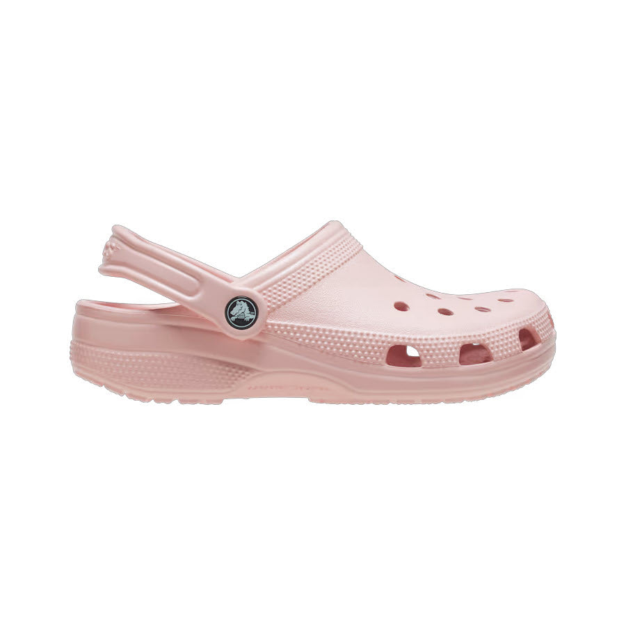 A light pink Crocs Classic Clog Quartz - Womens against a white background, featuring a strap and multiple ventilation holes.