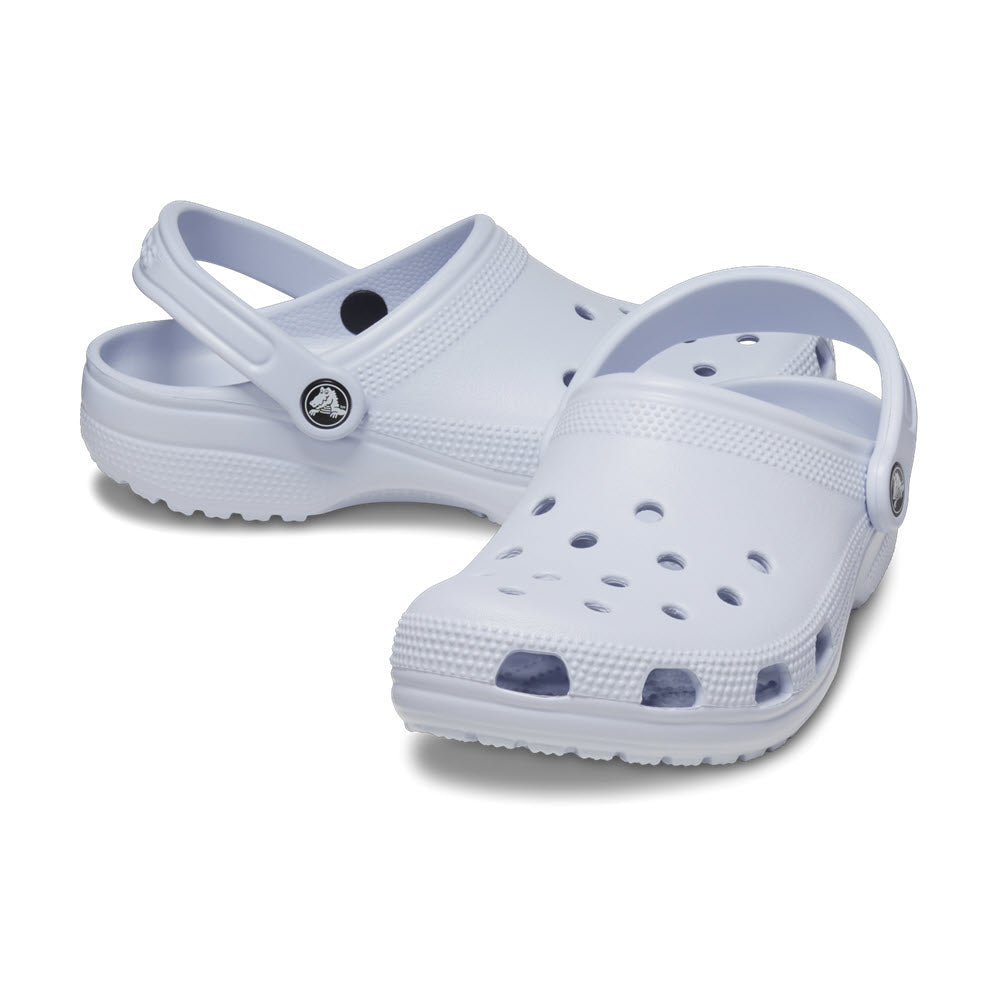 A pair of white Crocs Classic Clog Dreamscape - Womens with straps and multiple ventilation holes, displayed against a plain white background.