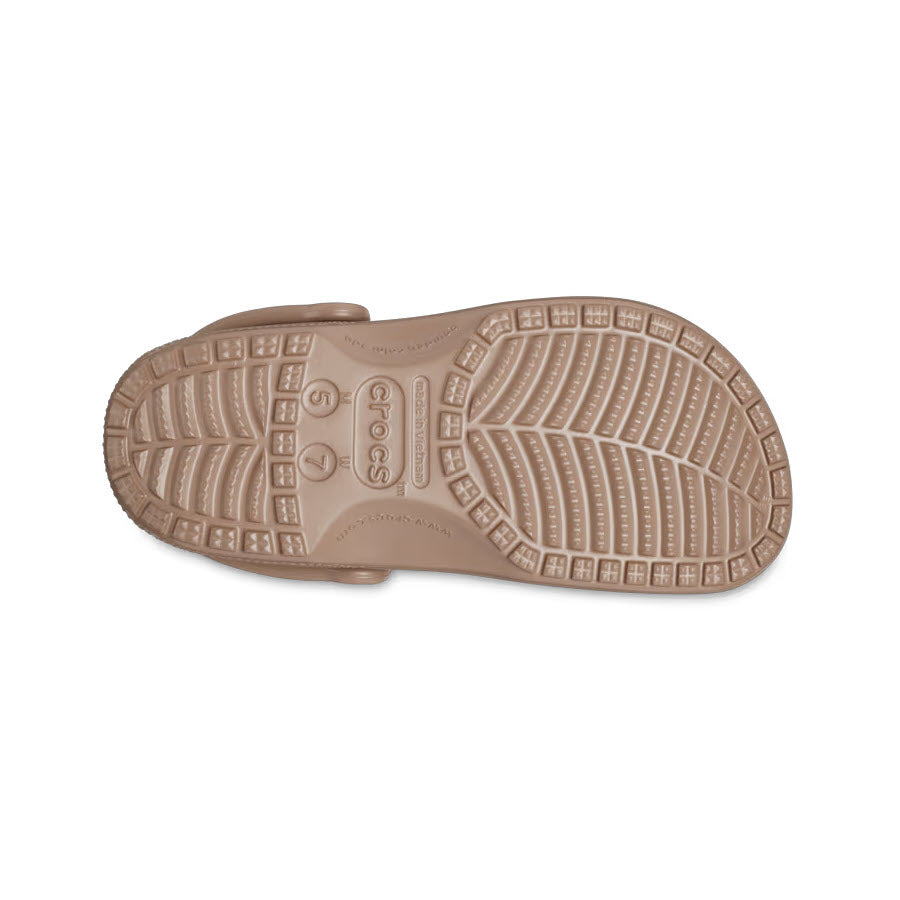 Sole of a light brown Crocs Classic Clog Latte displaying the textured design and branding details.