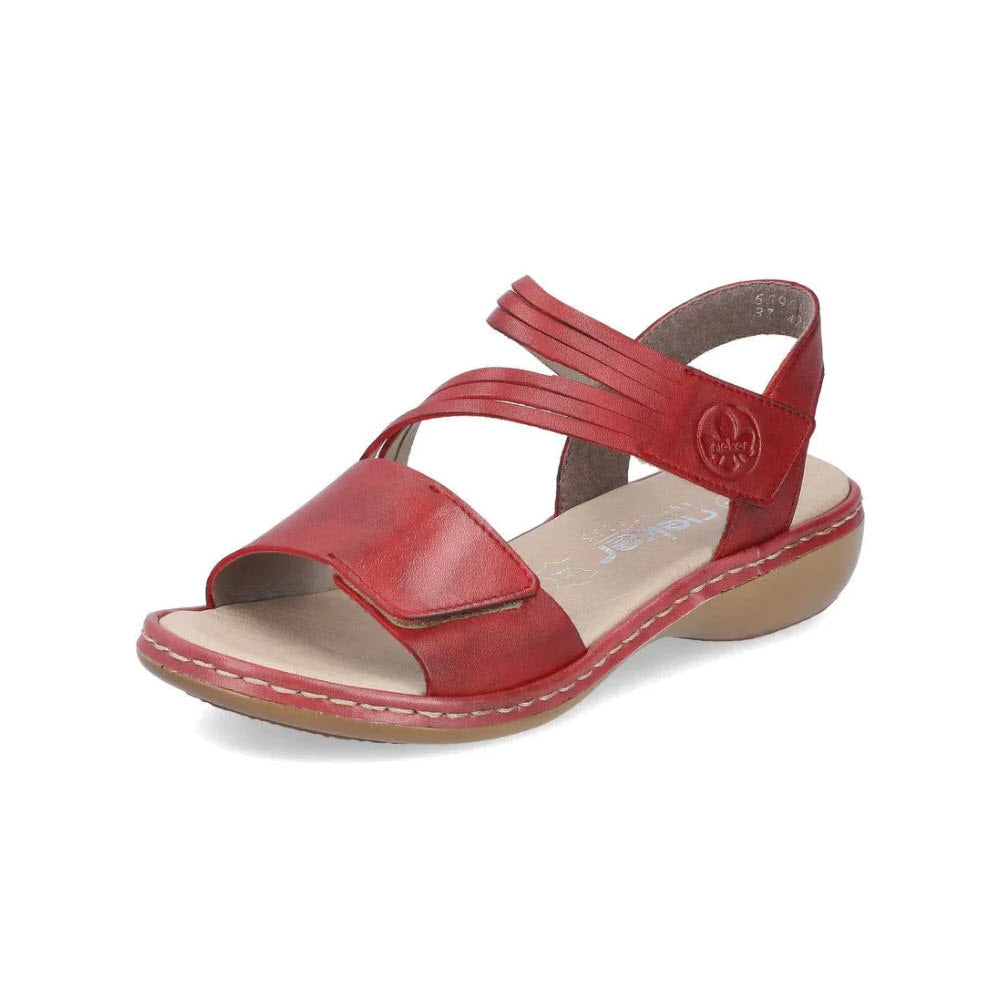 Rieker red smooth leather sandal with a low heel, crisscross straps, and a circular emblem, displayed on a white background.