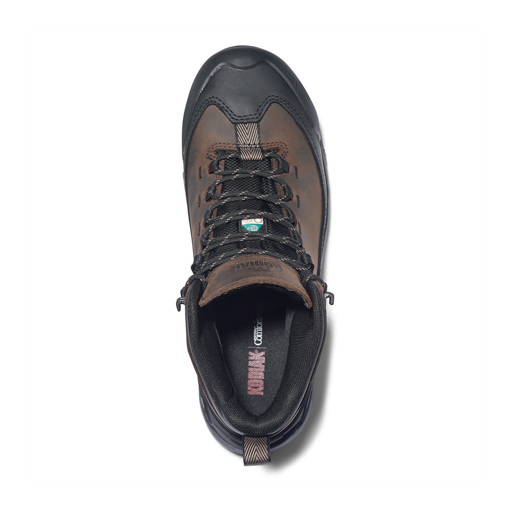 Top view of a single Kodiak Quest Bound Mid Composite Toe Waterproof Boot in dark brown with black and green accents, featuring a Vibram® TC4+ rubber outsole, displayed on a white background.