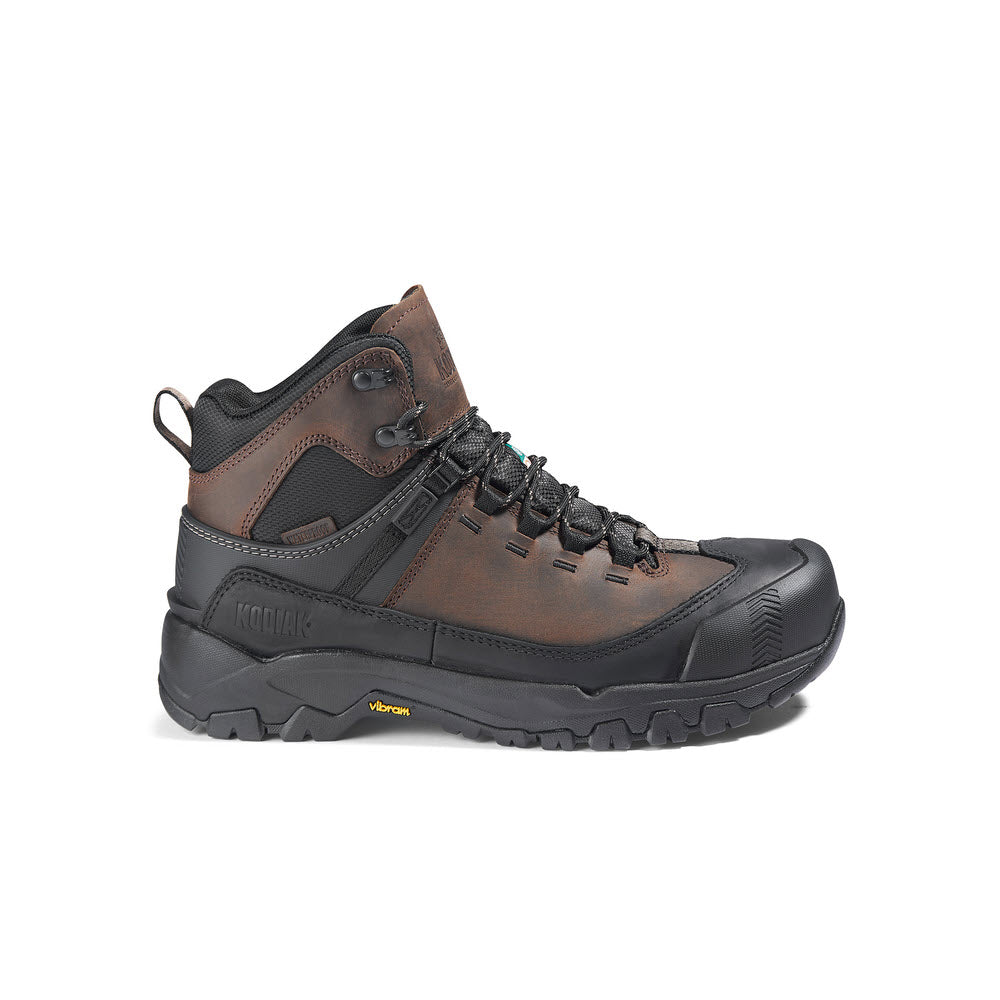 Brown leather Kodiak hiking boots with Vibram® TC4+ rubber outsole and yellow accents, displayed on a white background.