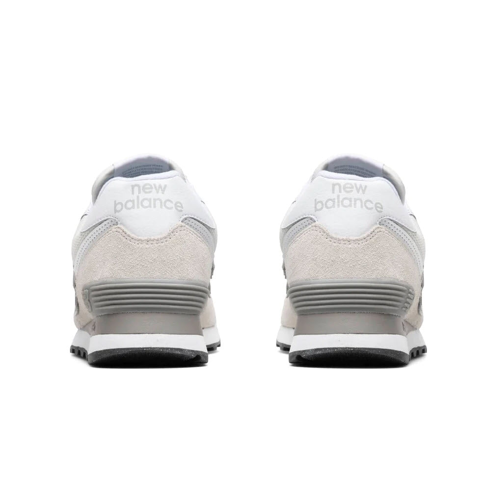 Rear view of two durable New Balance 574 Nimbus Cloud sneakers, showing the &quot;New Balance&quot; logo on a white background with gray accents.
