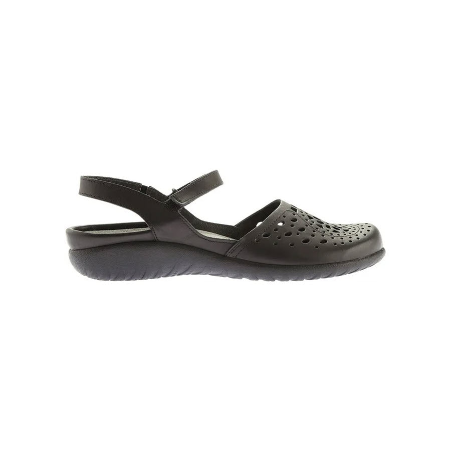 Side view of a Naot Arataki Black Raven women's sandal with a hook and loop closure and an anatomic cork & latex footbed, isolated on a white background.