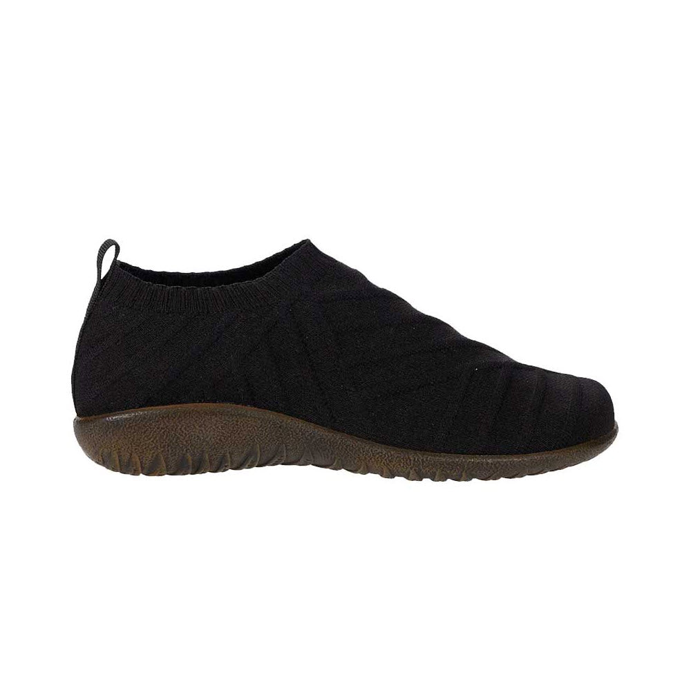 A Naot Okahu Black Knit slip-on sneaker with a textured sole and stretchy fabric upper, isolated on a white background.