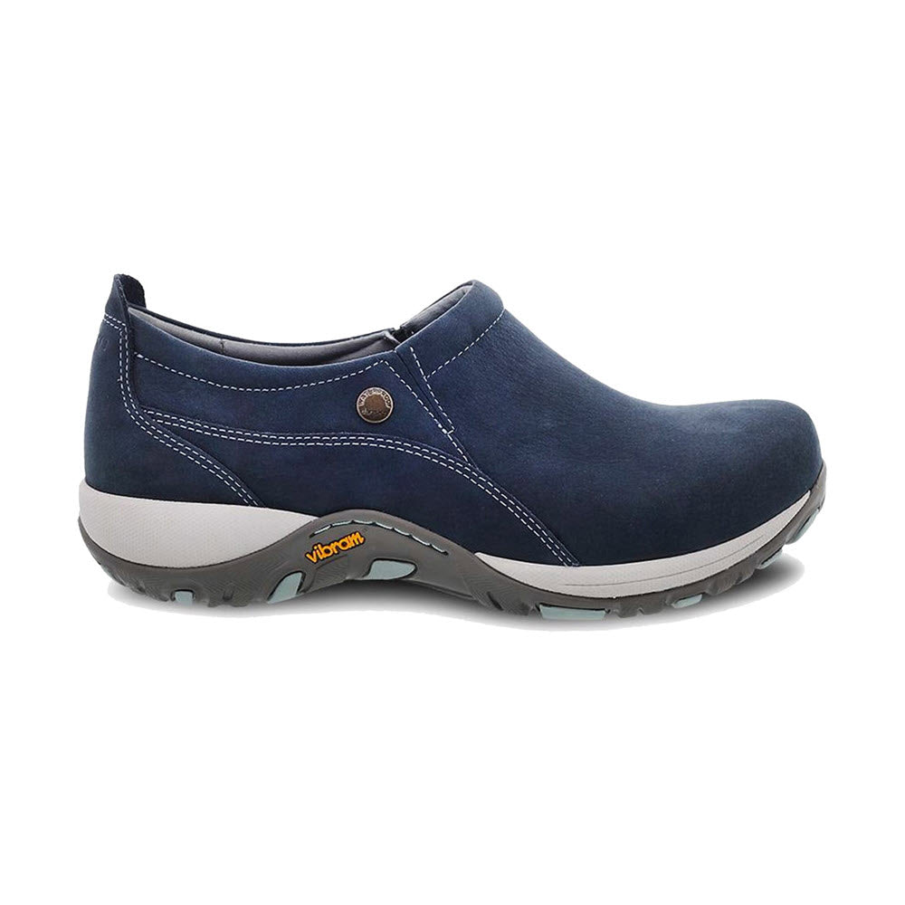 A single Dansko Patti Navy Milled Nubuck navy slip-on shoe with a waterproof leather upper, a white slip-resistant Virbam® sole, and a button detail on the side.