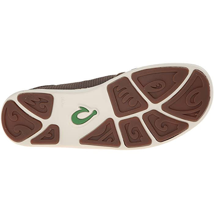 A close-up view of the sole of an Olukai Nohea Pae slip on Mustang shoe with a unique brown and white tread pattern and a green logo.