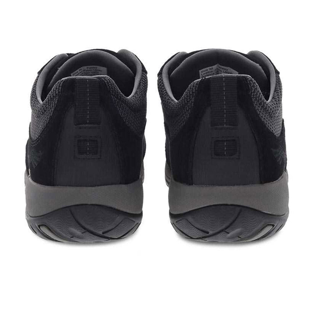 Rear view of a pair of Dansko Paisley Black/Black Suede women&#39;s sneakers with waterproof leather uppers against a white background.