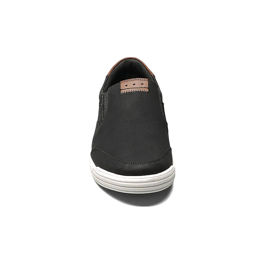 Nunn Bush Kore City Walk Slip-On shoe in black color with a white sole, viewed from the front, isolated on a white background.