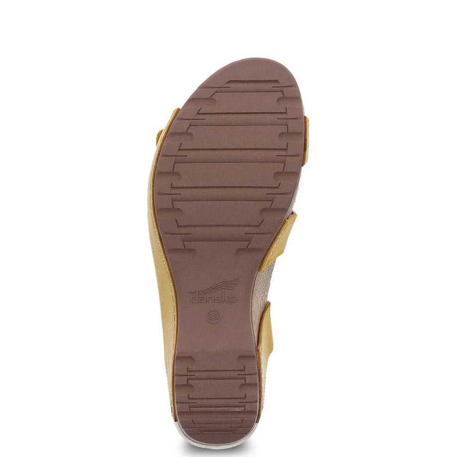 Sole of a Dansko Tarin Yellow Burnished Nubuck sandal against a white background.