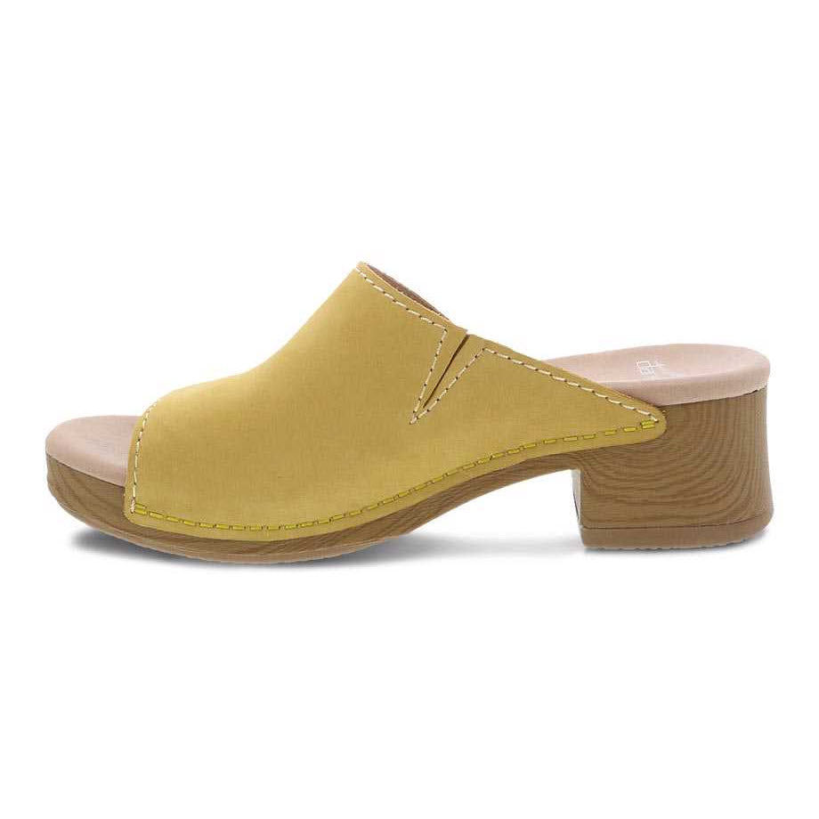 Dansko mustard yellow women&#39;s mule with a chunky block heel and stitched detailing.