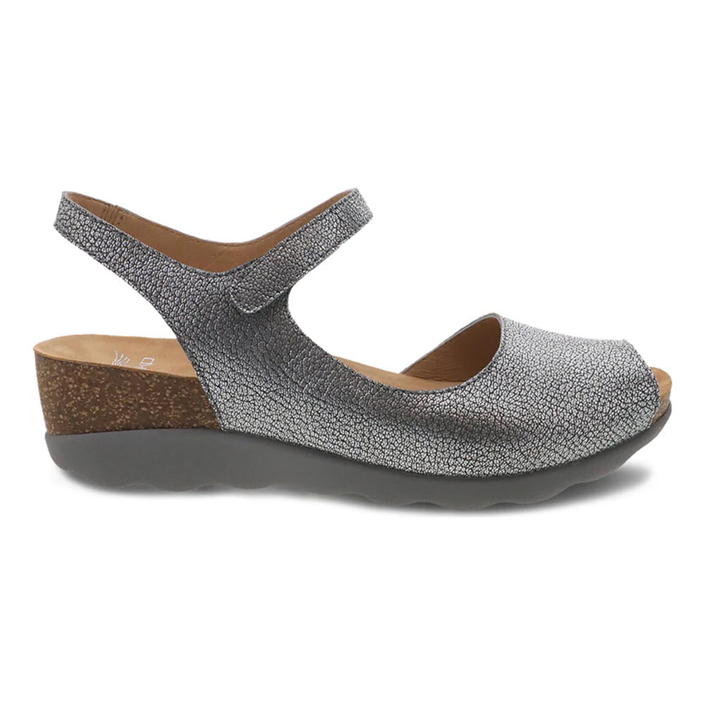 A single Dansko Marcy Pewter Metallic women's sandal with a cork heel and an adjustable ankle strap.