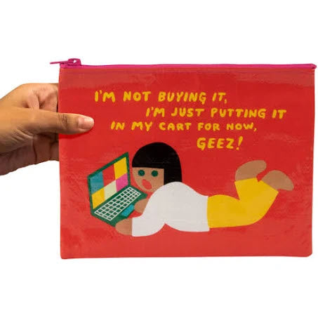 A hand holding a Blue Q Zipper Pouch Im Not Buying It, a red pouch with an illustration of a person on a laptop and the text "i'm not buying it, I'm just putting it in my cart for now.