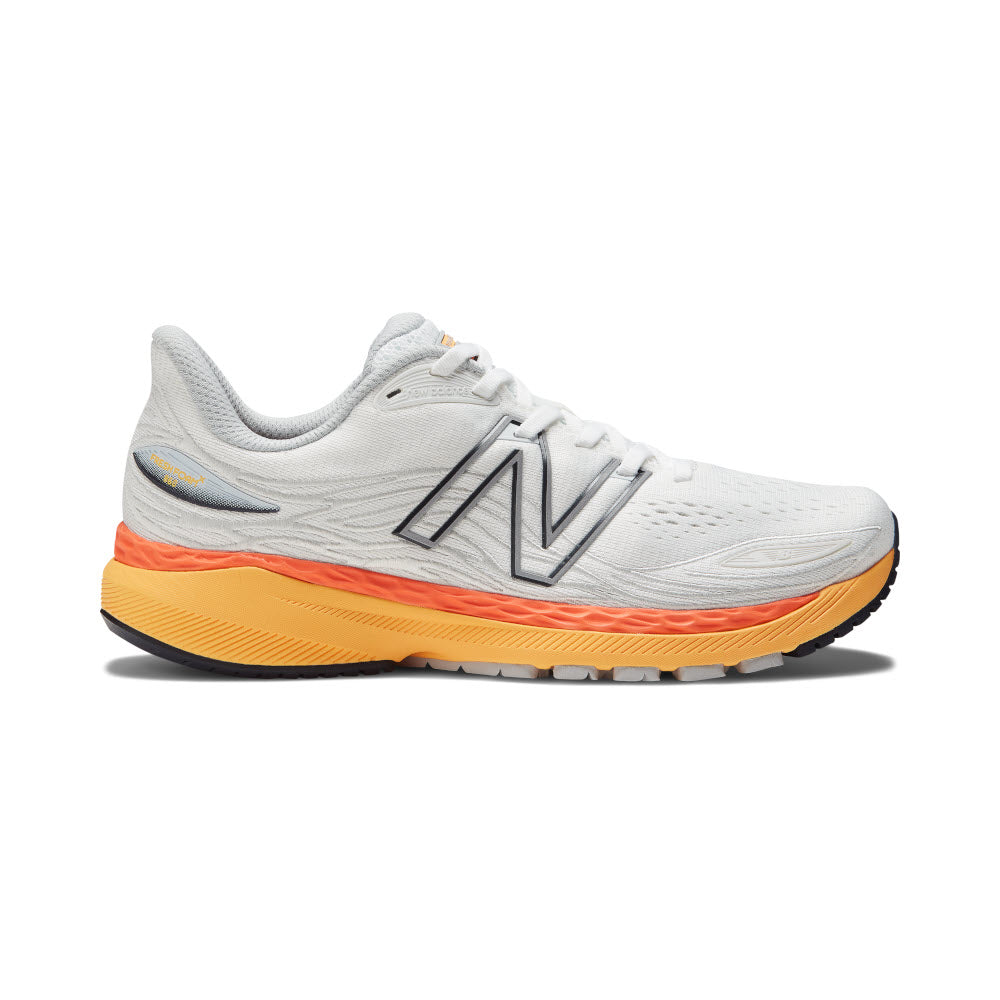 A New Balance 860v12 running shoe in white with contrasting orange and yellow sole, featuring prominent logo on the side and a supportive medial post.