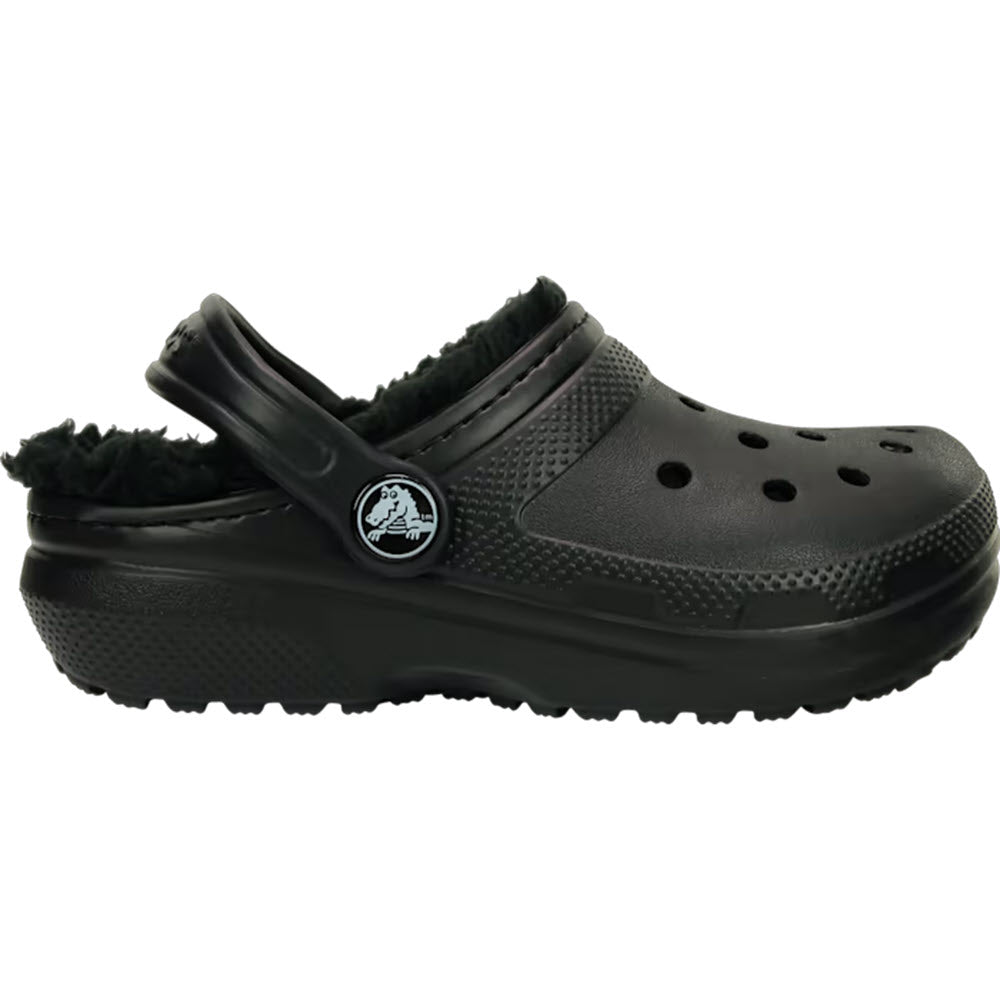 Black Crocs Classic Lined Clog Kids with ventilation holes and a pivoting heel strap, featuring a circular logo on the side and a fuzzy liner.