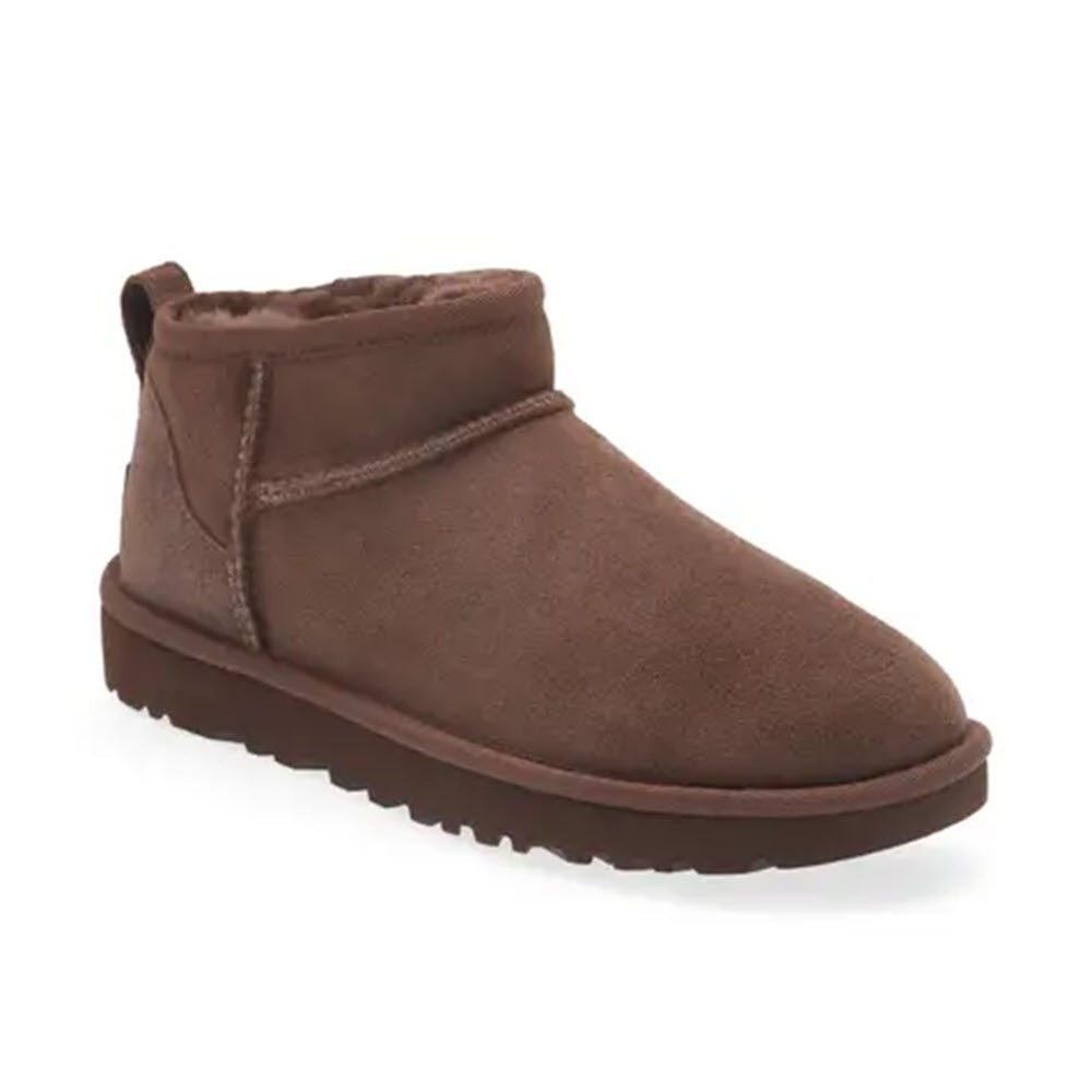 A brown suede UGG Classic Ultra Mini Burnt Cedar ankle boot with a flat sole.