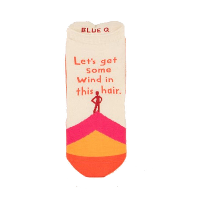 A single BLUE Q SNEAKER SOCK WIND IN HAIR made from breathable cotton, featuring a colorful design with an umbrella and the text "let's get some wind in this hair" on a white background.