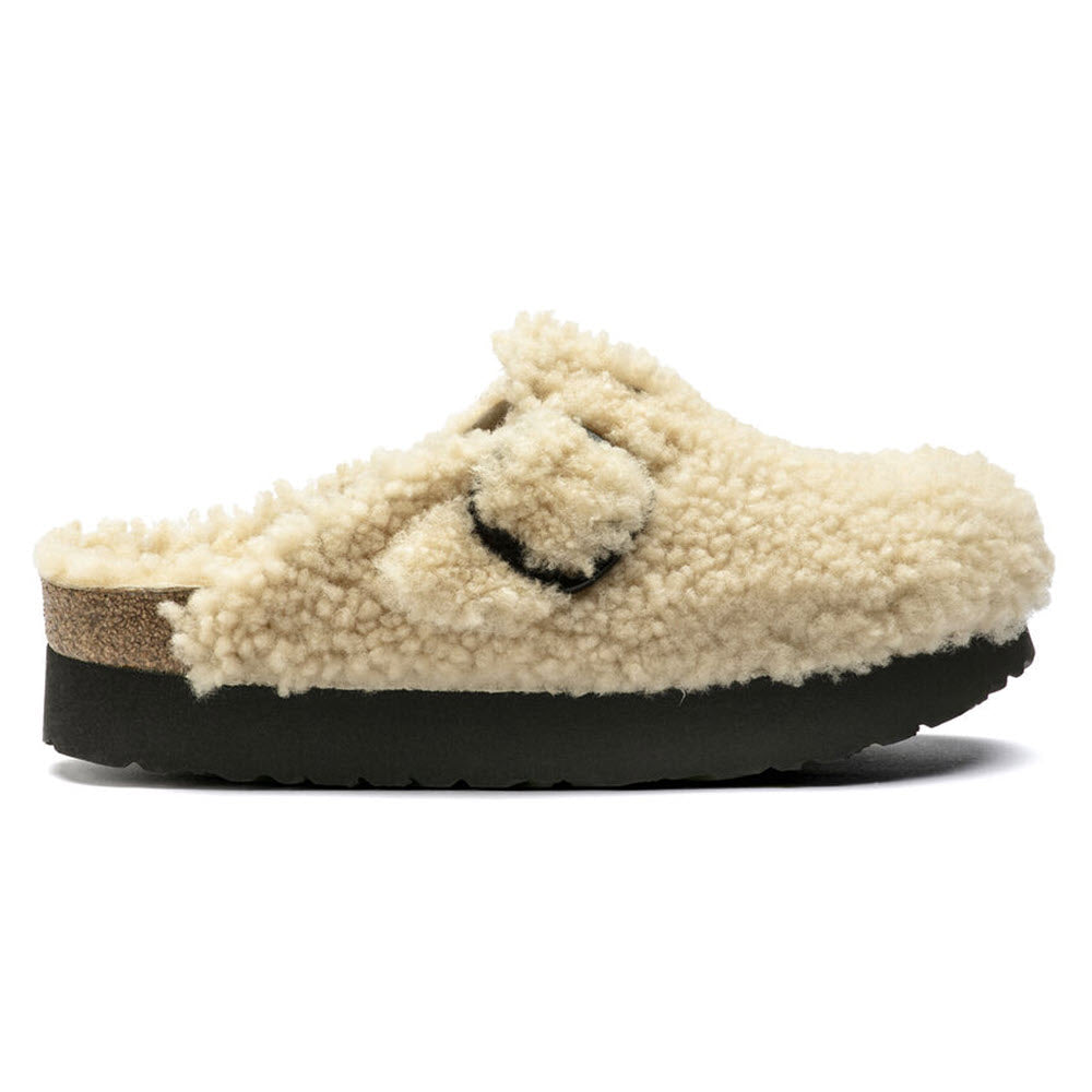 Fuzzy beige Birkenstock Boston Platform Big Buckle Teddy Eggshell Shearling clog with a thick black platform sole and a visible brand logo on the upper strap, isolated on a white background.