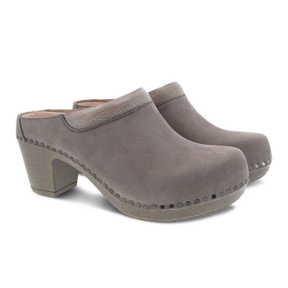 A pair of gray DANSKO SAMMY TAUPE NUBUCK clogs, featuring wooden heels and studded detailing.