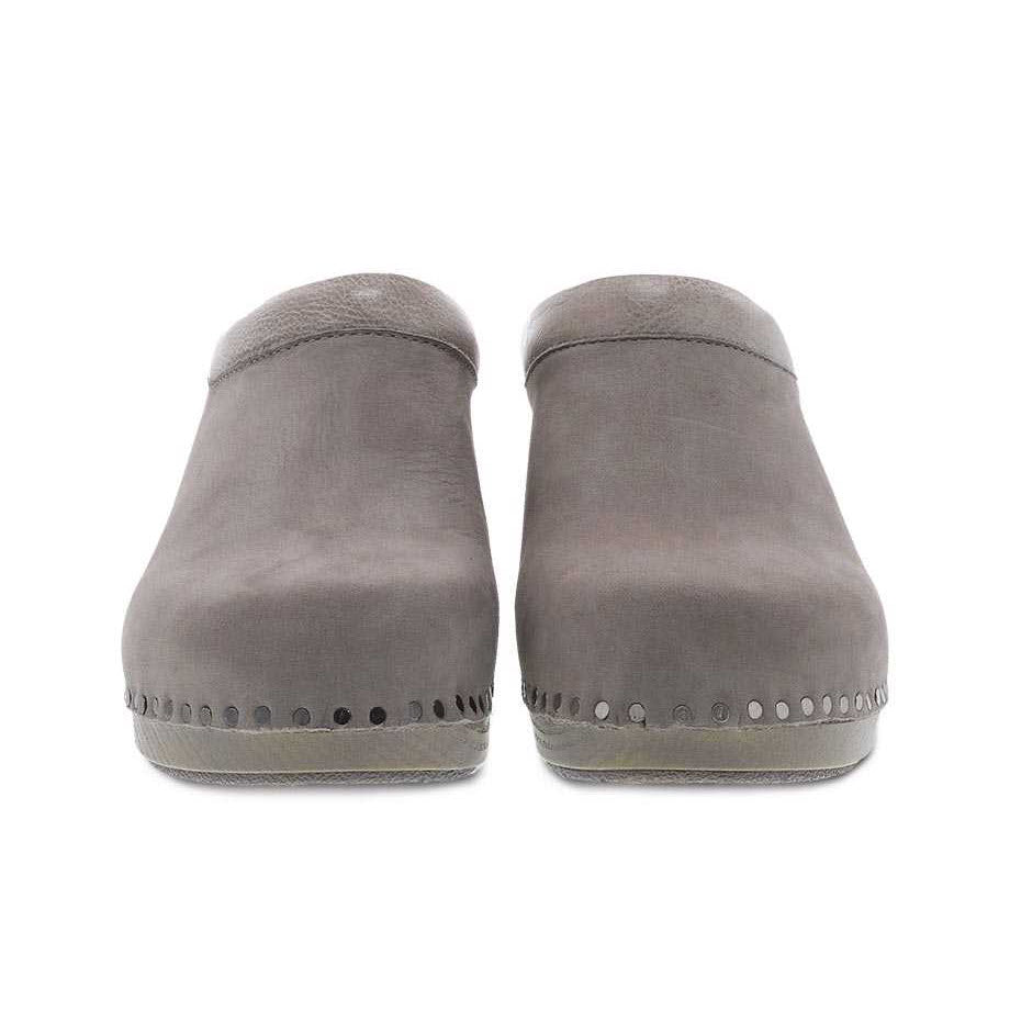 A pair of grey Dansko Sammy mule shoes with white stitching details and Nubuck uppers, viewed from the front.