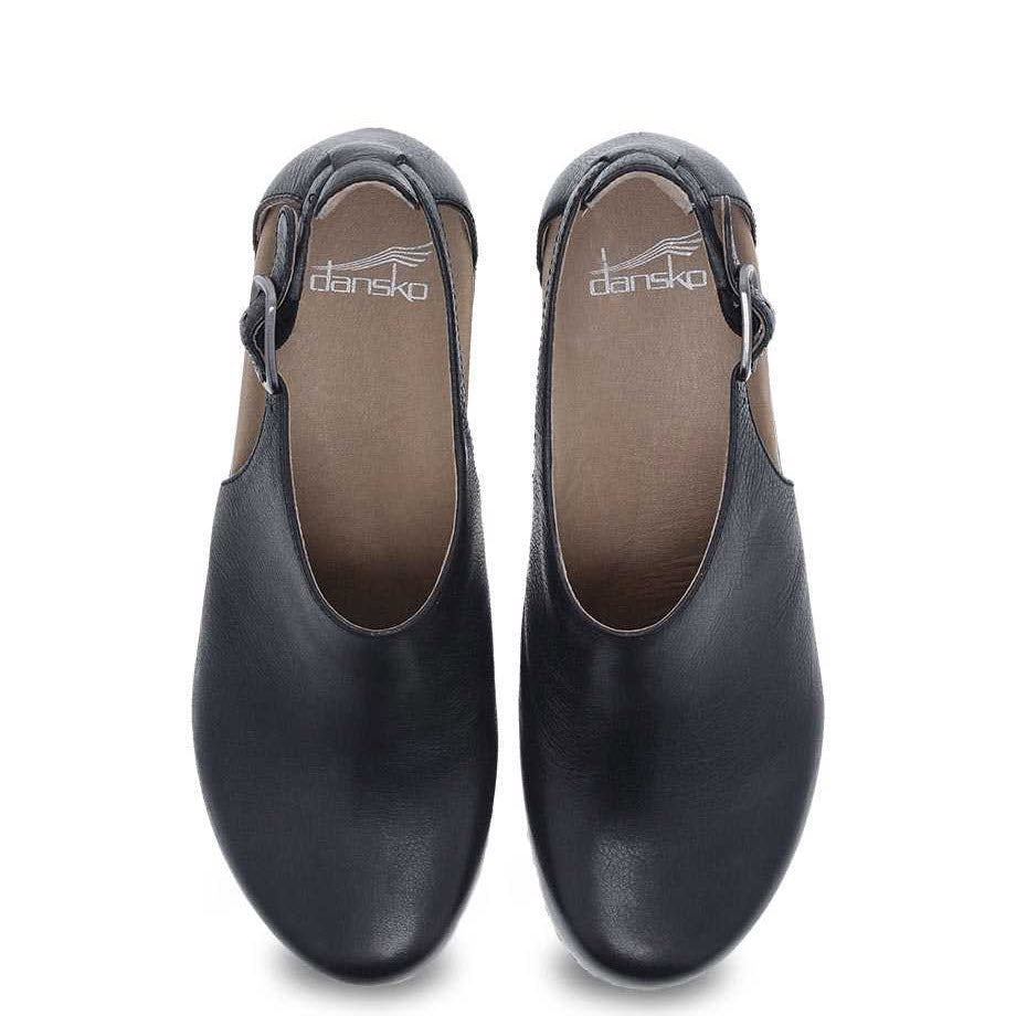 A pair of black Dansko SASSY BLACK clogs featuring Nubuck uppers against a white background.