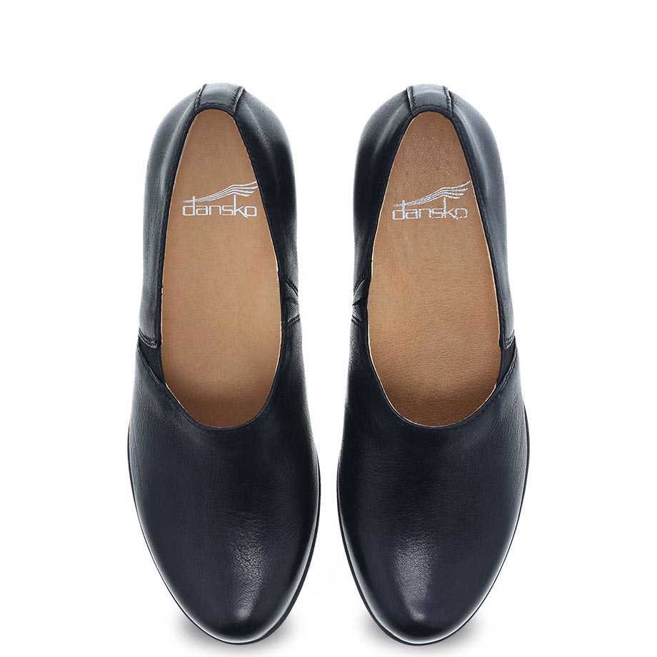 A pair of black Dansko Camdyn Black Burnished flats with Natural Arch technology, isolated on a white background.