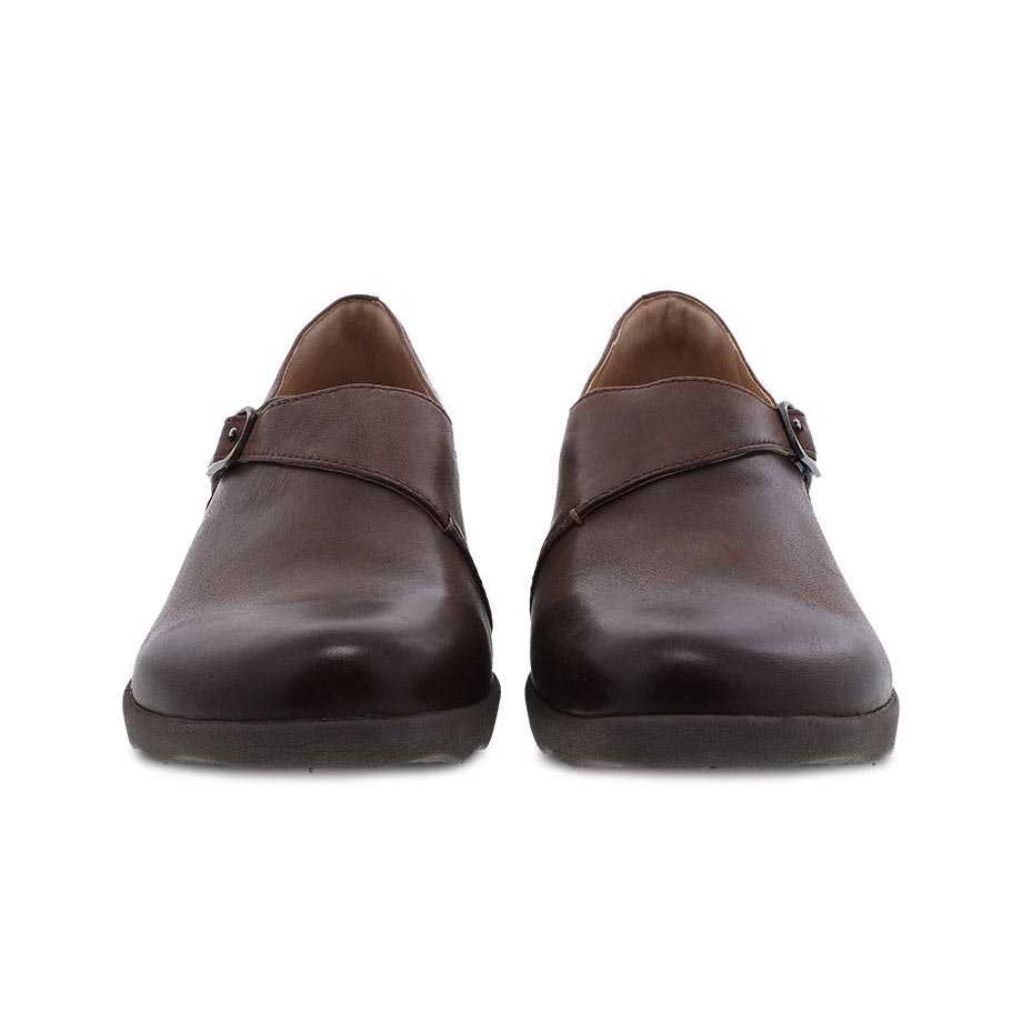 A pair of Dansko Marisa brown burnished leather loafers with leather uppers isolated on a white background.