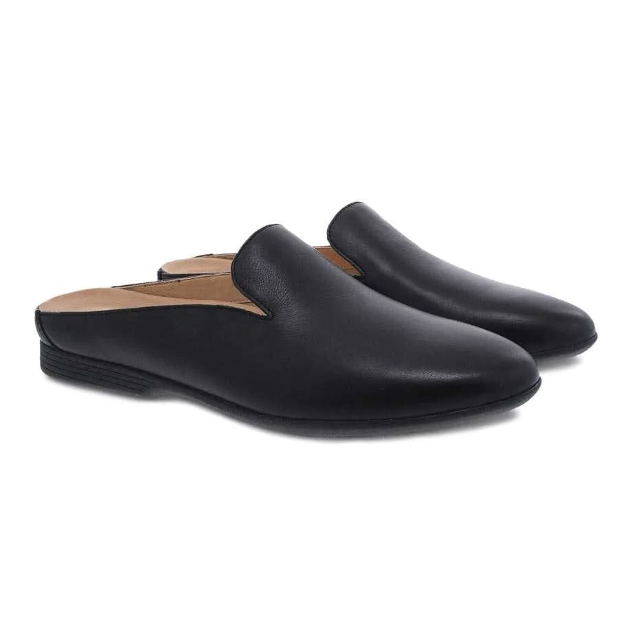 A pair of Dansko Lexie Black women&#39;s leather mules isolated on a white background.